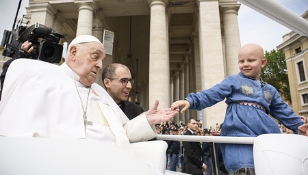 Papst Franziskus begrüßt ein Mädchen ohne Haare auf dem Petersplatz im Vatikan am 20. April 2025 auf dem Weg, um den Segen 'Urbi et orbi' vom Zentralbalkon des Petersdoms zu spenden.
