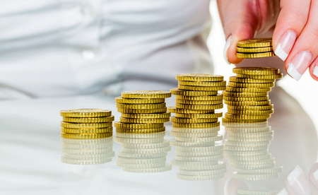 Frau mit Münzstapel beim Geld sparen / Erwin Wodicka - wodicka@aon.at