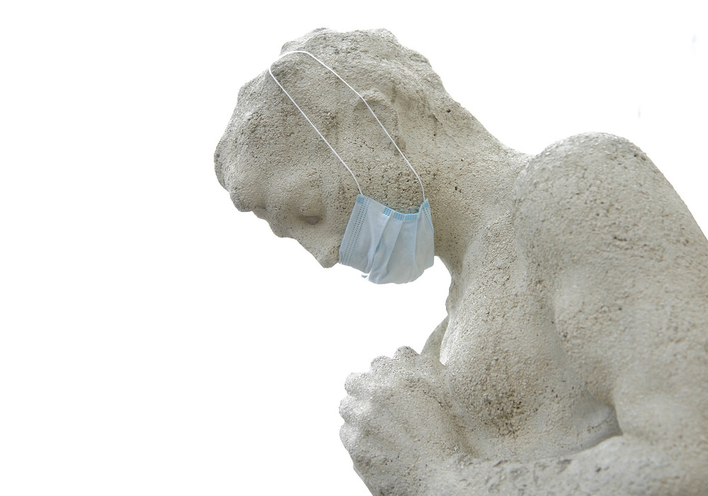 Statue eines betenden Menschen mit Mundschutz / kathpress/Pernsteiner Statue eines betenden Menschen mit Mundschutz