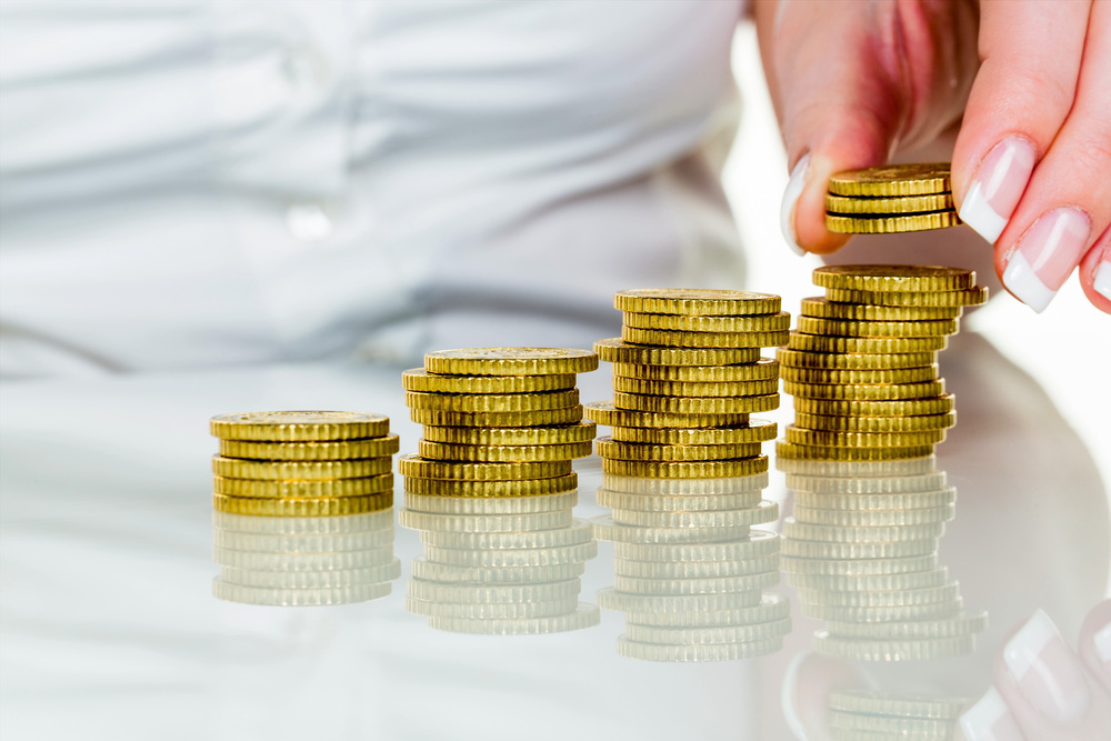 Frau mit Münzstapel beim Geld sparen / Erwin Wodicka - wodicka@aon.at Hilfswerke: Absetzbarkeit von Spenden und Kirchenbeitrag beibehalten
